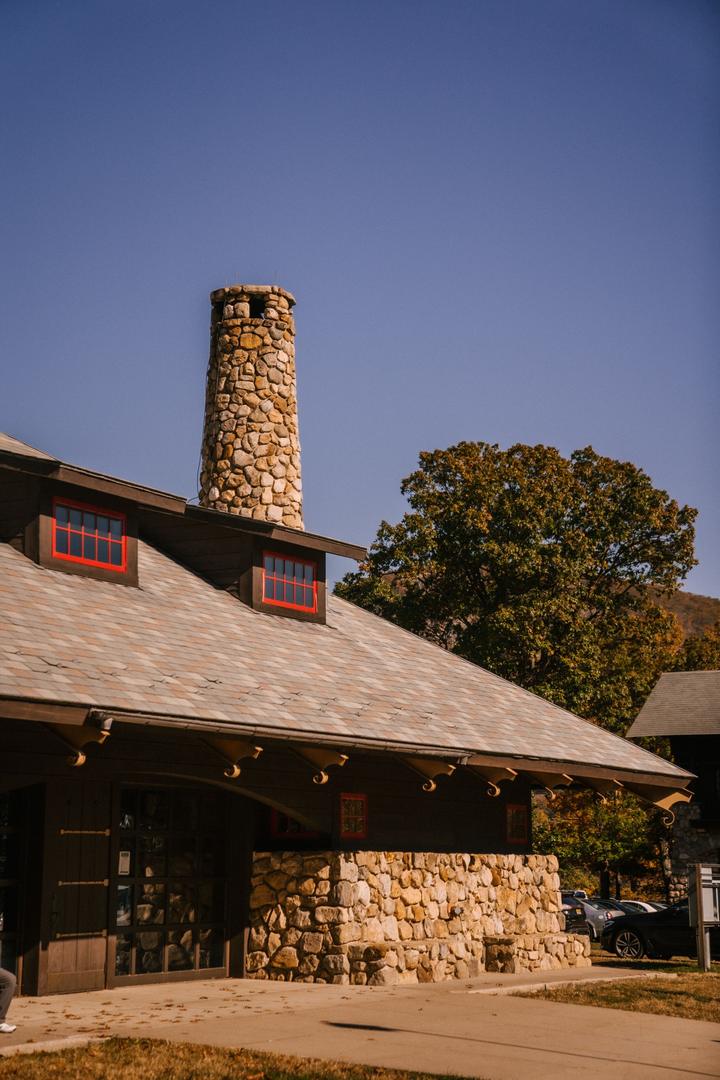 Stone chimney and porch on a house under a blue sky